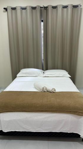 a large white bed with a towel on it at Residencial Ebenezer conforto perto da ufac in Rio Branco