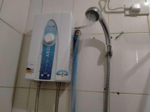a shower head on a wall in a bathroom at Jenny's transient house in Baguio