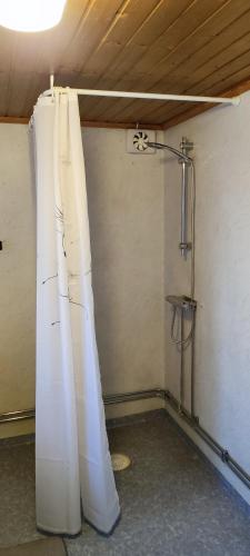 a room with a shower with white curtains in it at The Red Butterfly 2 cottage in Månstad