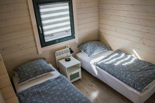two twin beds in a room with a window at Domki Aleja Róż in Międzyzdroje