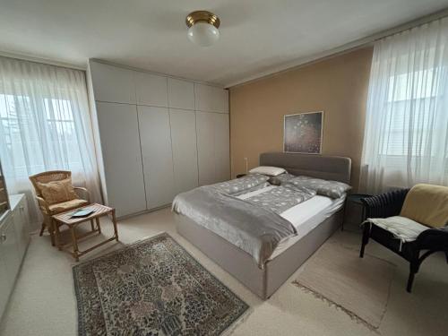 a bedroom with a bed and a chair and window at Haus Doris in Perchtoldsdorf