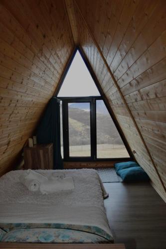 a bed in a room with a large window at ''Sunflower'' in Dushetʼi