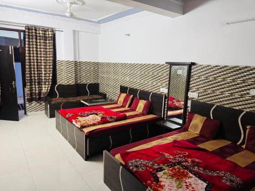 a room with two beds and a couch at Hotel Amrit in Bharwain