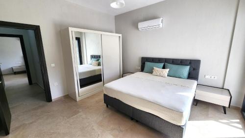 a bedroom with a large bed and a mirror at Villa Melara in Kızılyurd