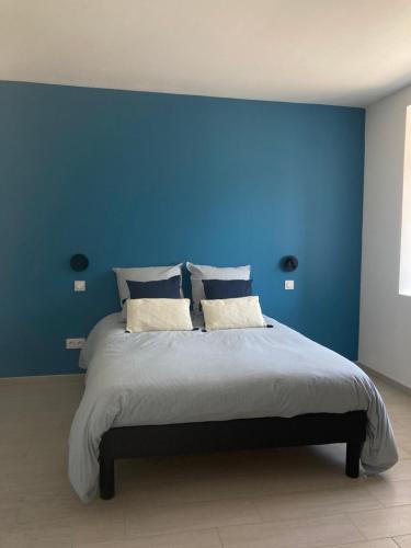 a blue bedroom with a large bed with blue walls at Gîte Les Douets in Isigny-le-Buat