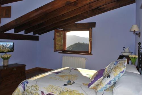 a bedroom with a bed and a window at Apart con piscina Lebanes Picos de Europa in Torices