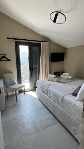 a bedroom with two beds and a chair and a window at Villa Loggia in Ferendináta