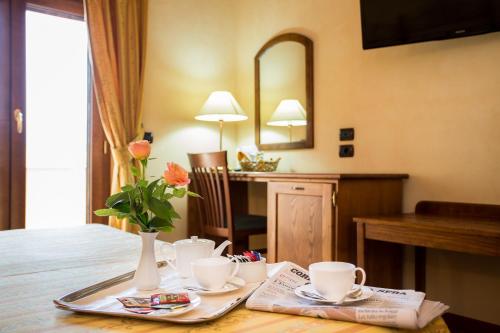 a table with two cups and a vase with flowers on it at Villa Santa Caterina in Montalto Uffugo
