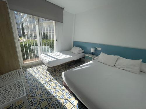 a small room with a bed and a window at Apartamento 1ª linea by Hugo Beach Hotel - Familias in Gandía