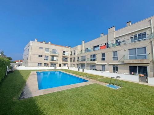 an apartment with a swimming pool in front of a building at Apartment by the sea & town in Esposende