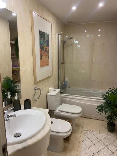 a bathroom with a sink and a toilet and a tub at Apartment by the sea & town in Esposende
