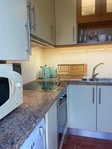 a kitchen with a counter top with a microwave at Apartment by the sea & town in Esposende