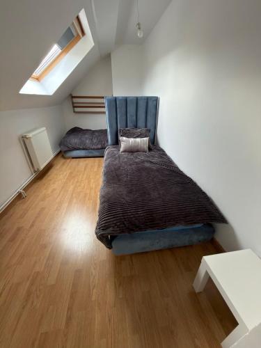 a bedroom with a bed with a blue chair in it at Maison de village in Mecquignies