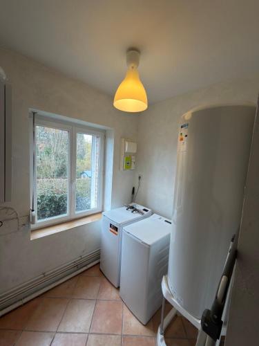 a kitchen with a washer and dryer and a window at Maison de village in Mecquignies