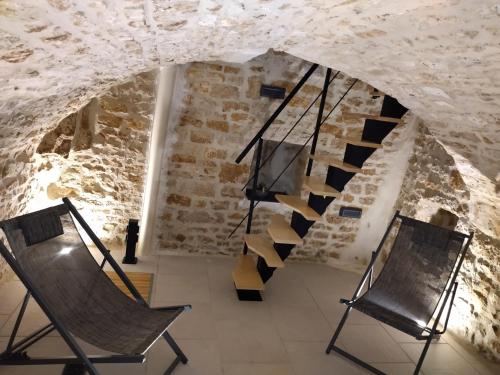 une pièce avec deux chaises et un escalier en colimaçon dans l'établissement Gite l'Amazonite, à Laville-aux-Bois