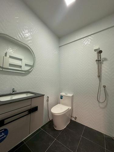 a bathroom with a toilet and a sink and a shower at Apples Pattaya Townhouse in Pattaya South