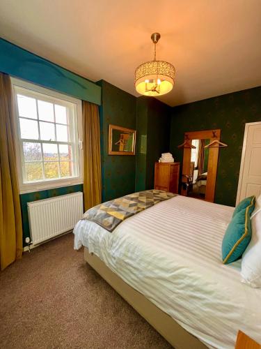 a bedroom with a large bed and a chandelier at Old Spittal Hospital Apartment - Free Parking in Stirling