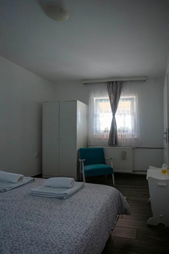 a bedroom with a bed and a chair and a window at Apartman Marija in Bošnjaci