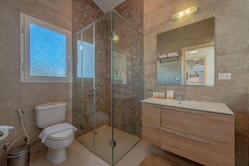 a bathroom with a toilet and a glass shower at unique flat_ garden and lagoon in Hurghada