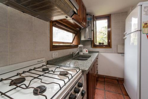 
a kitchen with a stove top oven and a sink at Cabañas Gonzalez in Villa Gesell

