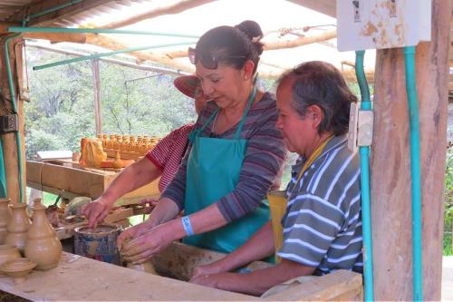 Dos mujeres están haciendo jarrones en un taller en Posada De Los Santos Hotel Rural, La Candelaria, en Ráquira