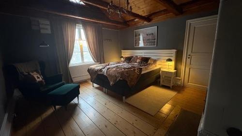 a bedroom with a bed and a chair and a window at Ranchen B&B in Enköping