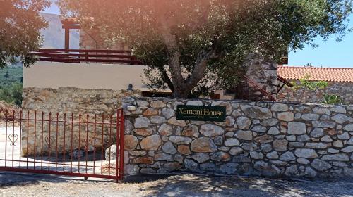 a stone wall with a tree behind a fence at Xemoni House in Koíta