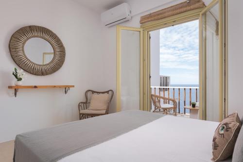 a bedroom with a bed and a view of the ocean at Kastella Sunset Villa Three in Kithnos