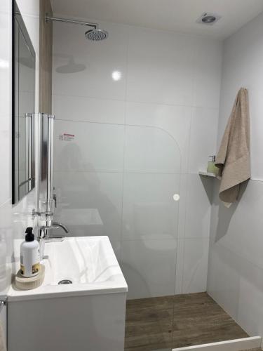 a white bathroom with a sink and a shower at Estudio 63 in Neuquén