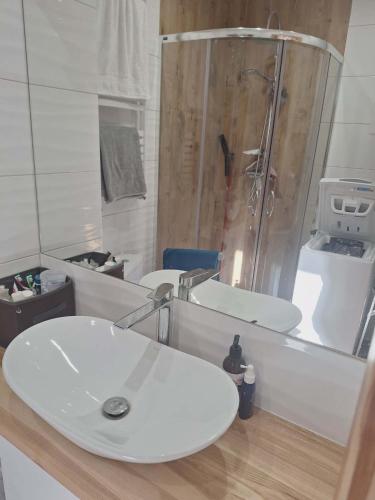 a bathroom with a white sink and a shower at Apartament Lipowa in Lidzbark