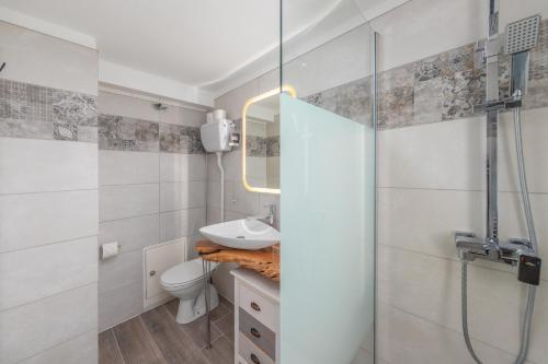 a bathroom with a sink and a toilet and a shower at LA TERRAZZA appartamento di vacanza in Collina d'Oro