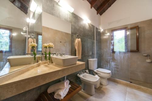 a bathroom with two sinks and a toilet and a shower at Cabañas Gonzalez in Villa Gesell