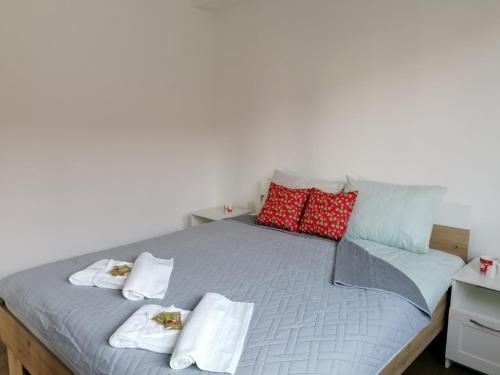a bed with red and white pillows on it at Vila Ella Mavrovo in Mavrovo