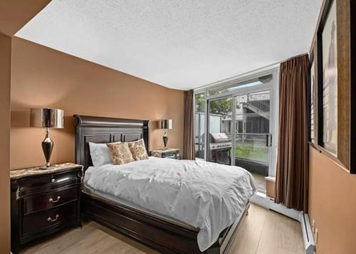 a bedroom with a bed and a large window at Modern 2BR Luxury Apartment - Amazing Location, Steps To Everything! in Vancouver