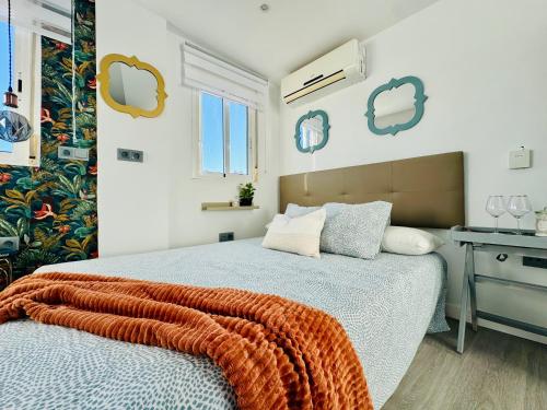 a bedroom with a bed with an orange blanket on it at Mini Estudio Málaga in Málaga