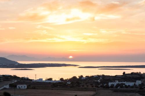 a sunset over a large body of water at Anna Platanou Suites in Agia Irini Paros