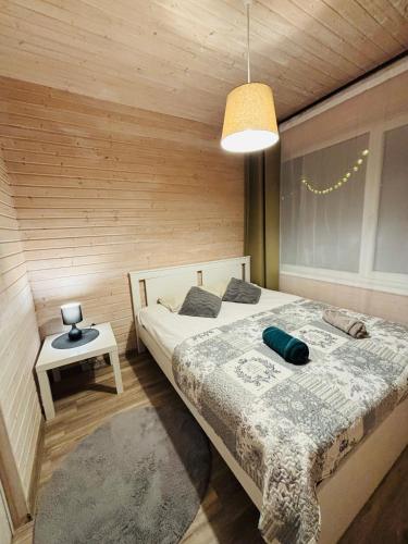 a bedroom with a bed in a wooden wall at Sodyba Po klevu in Molėtai