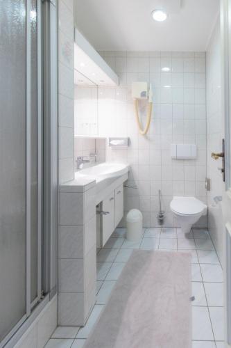 a white bathroom with a sink and a toilet at Landhaus Süchterscheid in Süchterscheid
