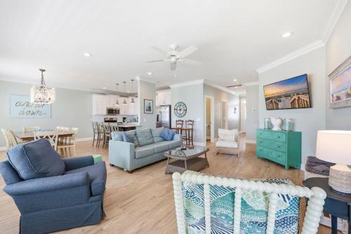 a living room with blue furniture and a dining room at Anchor Down Luxury Ocean View Beach House w Pool in Myrtle Beach