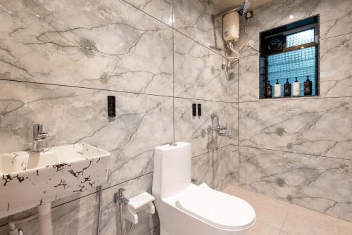 a bathroom with a toilet and a sink at Cabanas Retreat in Revadanda