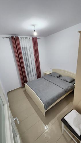a bedroom with a bed in a white room at Diamond Apartment Vlore in Vlorë