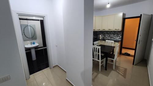 a view of a bathroom with a sink and a kitchen at Diamond Apartment Vlore in Vlorë