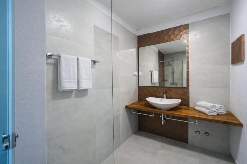 a bathroom with a sink and a glass shower at Aparthotel Dalmacija in Privlaka