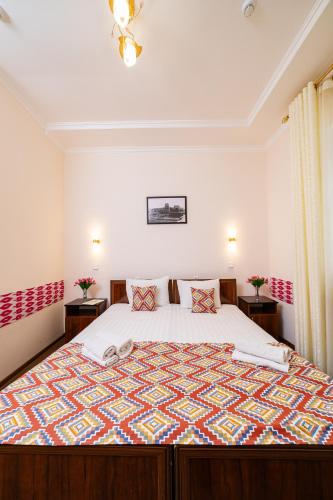 a bedroom with a large bed and two tables at Caravan Boutique Ichan Kala in Khiva