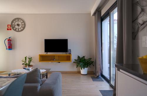 a living room with a couch and a tv at Moonfall House in Arco da Calheta