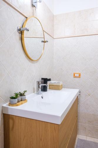 a bathroom with a sink and a mirror at La Dolce Imola-Bilocale in centro storico in Imola