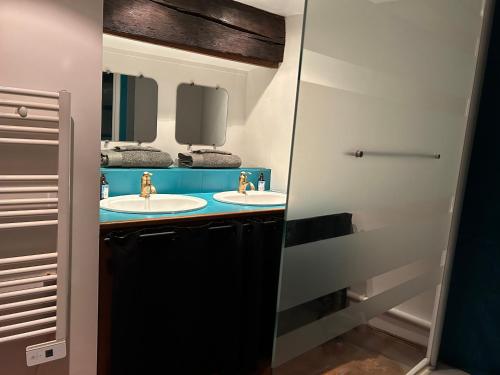 a bathroom with two sinks and a mirror at Dupplex, centre ville in Blois