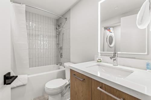 a white bathroom with a sink and a toilet at Modern mountain luxury with stunning views in Canmore