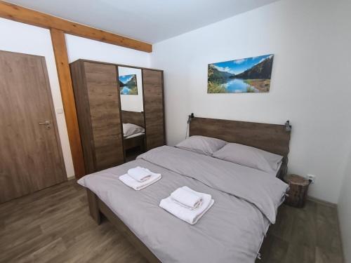 a bedroom with a bed with two towels on it at Horský apartmán U Čerťáka in Horní Václavov