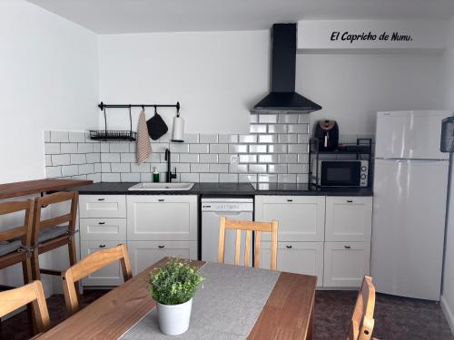 a kitchen with a table and a refrigerator at El Capricho de Nunu SIMANCAS in Simancas